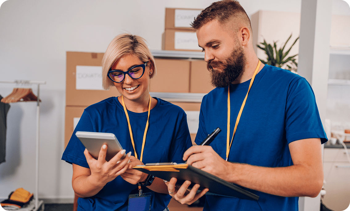 Warehouse workers reviewing inventory on tablet